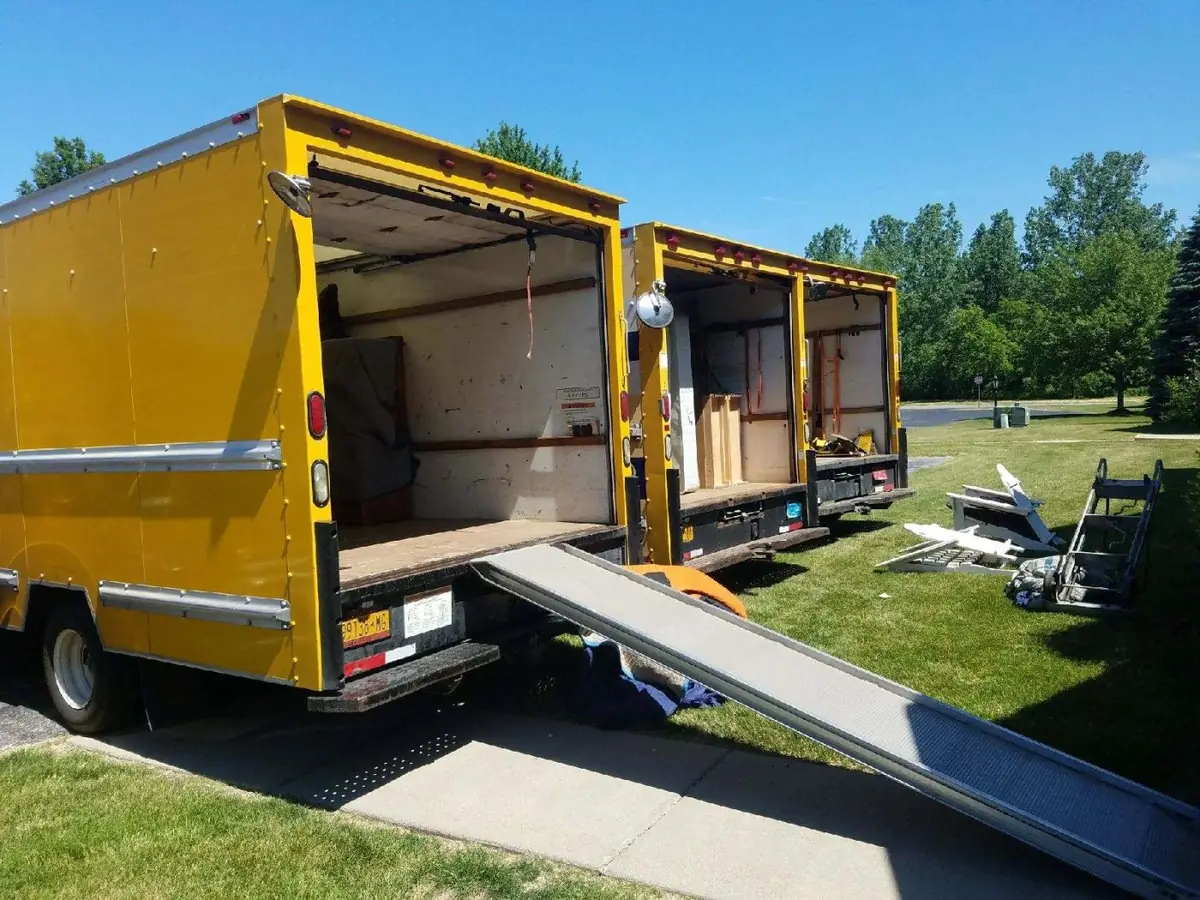Moving truck with loading ramp down at a home
